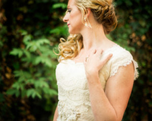 Portraits, Picture of a bride in her wedding dress looking away from the camera showing off her wedding ring